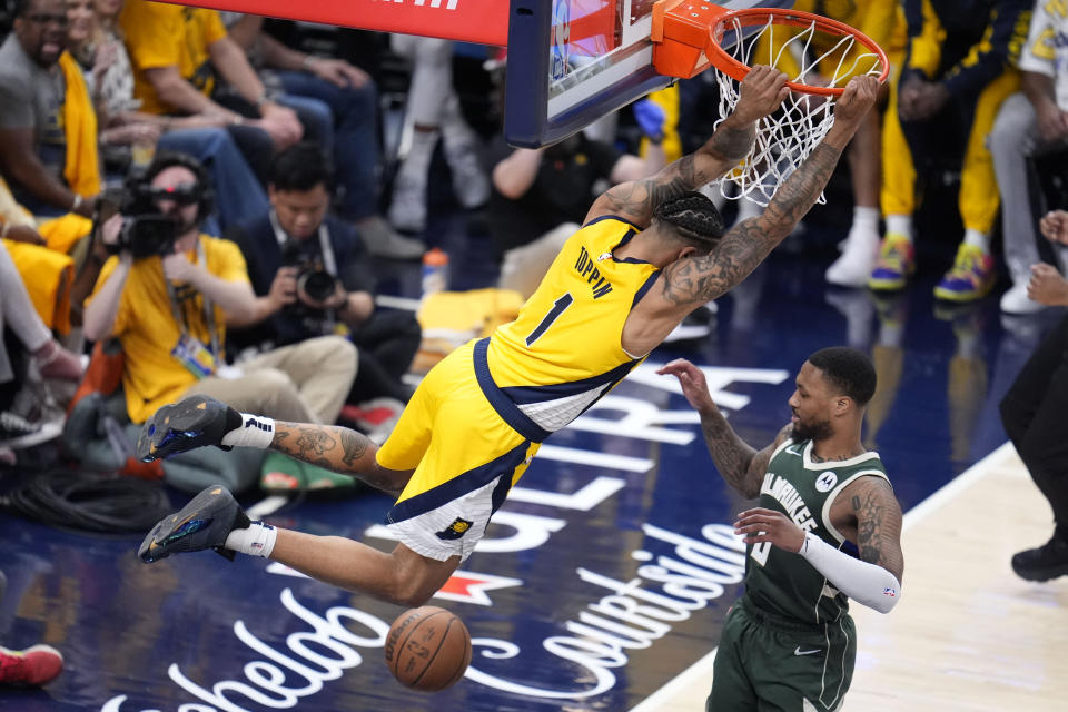 Indiana Pacers forward Obi Toppin (1) dunks the ball over Milwaukee Bucks guard Damian Lillard (0) during the second half in Game 6 in an NBA basketball first-round playoff series, Thursday, May 2, 2024, in Indianapolis. (AP Photo/Michael Conroy)