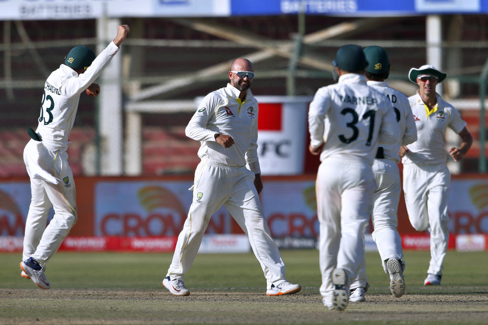 Australia's Nathan Lyon, center, and teammates celebrate after the dismissal of Pakistan's Babar Azam on the fifth day of the second test match between Pakistan and Australia at the National Stadium in Karachi Pakistan, Wednesday, March 16, 2022. (AP Photo/Anjum Naveed)