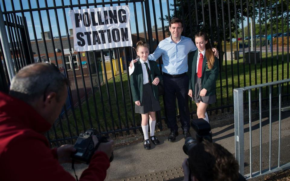 Andy Burnham poses with his daughters Annie and Rosie as he arrives at Golborne Community Primary school to cast his vote in the Greater Manchester mayoral election, for which he is standing as a candidate - Credit: Oli Scarff/AFP