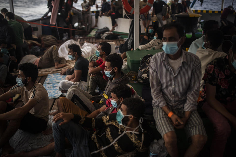 Migrants from different nationalities, mainly from Somalia, Egypt and Morocco, but also from Libya, Sierra Leone, Ivory Coat, Bangladesh, Senegal, Syria, Palestine, Benin and Tunisia, including 14 minors and 4 women, rest on board the Spanish NGO Open Arms vessel on Wednesday 9, 2020, after being rescued last Tuesday night as they were trying to flee Libya on board a precarious wooden boat, in international waters, in the Central Mediterranean sea. (AP Photo/Santi Palacios)