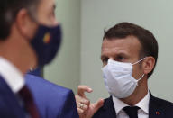 French President Emmanuel Macron, right, attends a round table meeting at an EU summit at the European Council building in Brussels, Thursday, Oct. 15, 2020. European Union leaders are meeting in person for a two-day summit amid the worsening coronavirus pandemic to discuss topics ranging from Brexit to climate and relations with Africa. (Yves Herman, Pool via AP)