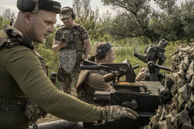 Soldados ucranianos de la 67ª Brigada Mecanizada Separada realizan ajustes en un obús para disparar proyectiles de artillería hacia posiciones rusas, cerca de Kreminna, Ucrania, el 6 de julio de 2023.  (Mauricio Lima/The New York Times)