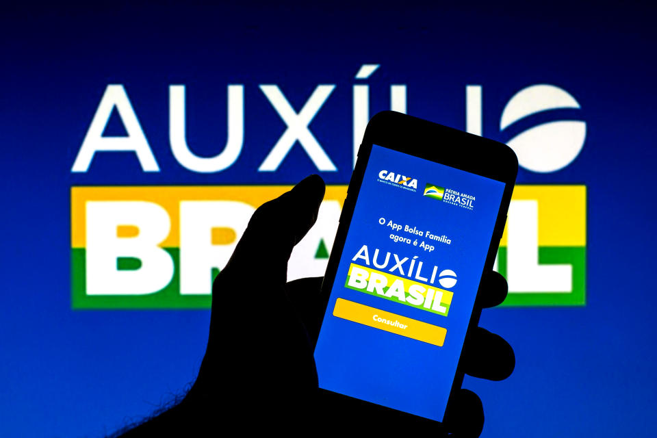 SPAIN - 2021/12/09: In this photo illustration an Auxilio Brasil app seen displayed on a smartphone with an Auxilio Brasil logo in the background. (Photo Illustration by Thiago Prudencio/SOPA Images/LightRocket via Getty Images)