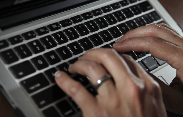 FILE- A person types on a laptop keyboard in North Andover, Mass, June 19, 2017. The U.S. government will restrict its use of commercial spyware tools that have been used to surveil human rights activists, journalists and dissidents around the world, under an executive order issued Monday, Oct. 27, 2023, by President Joe Biden. (AP Photo/Elise Amendola, File)