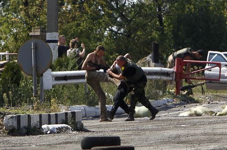 Ukrainian servicemen detain a pro-Russian activist at a checkpoint near the eastern Ukrainian town of Debaltseve, August 16, 2014. REUTERS/Valentyn Ogirenko