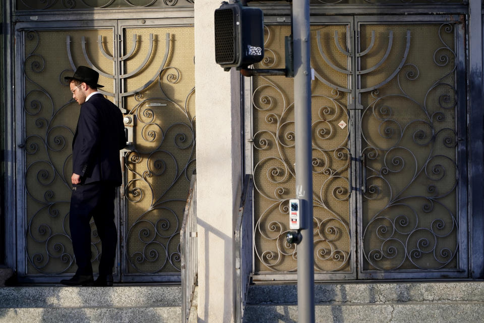 A man stands at the doors of the Congregation Shaarei Tefila synagogue in Los Angeles on Saturday, Oct. 7, 2023. (AP Photo/Damian Dovarganes)