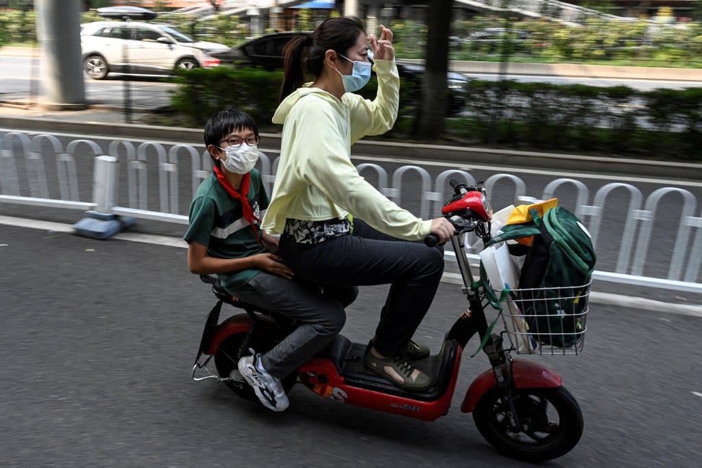 File: A student leaves on a scooter following the end of the day’s school session in Beijing on 10 September 2021 (AFP via Getty Images)