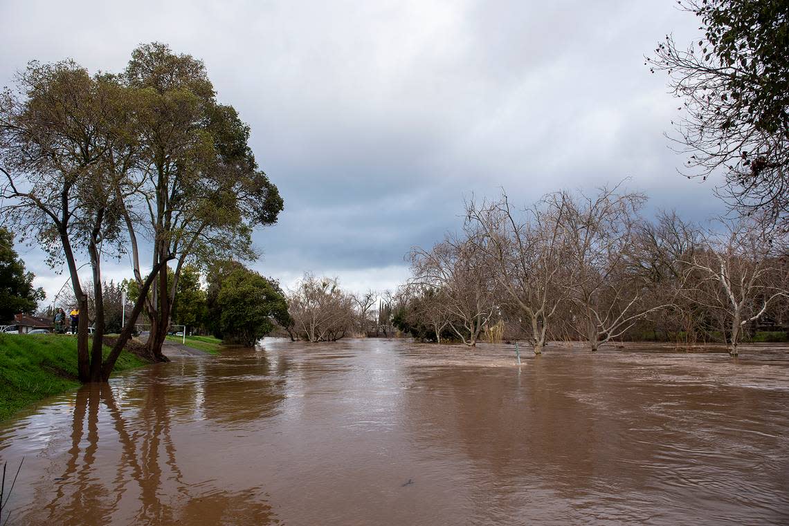 Bear Creek flows past G Street flooding the Michael O. Sullivan bike path and the surrounding area in Merced, Calif, on Tuesday, Jan. 10, 2023.