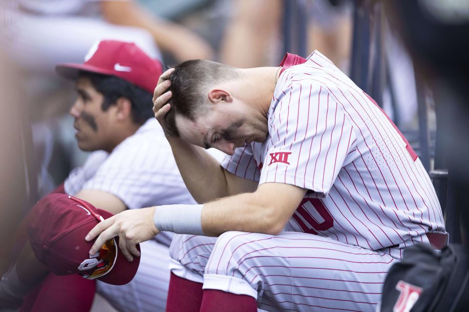 Oklahoma's Tanner Tredaway sits in the dugout following their 4-2 loss against Mississippi in Game 2 of the NCAA College World Series baseball finals, Sunday, June 26, 2022, in Omaha, Neb. Mississippi defeated Oklahoma 4-2 to win the championship. (AP Photo/Rebecca S. Gratz)