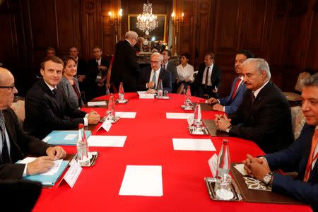 French President Emmanuel Macron (2ndL) and General Khalifa Haftar (2ndR), commander in the Libyan National Army (LNA), attend a meeting for talks over a political deal to help end Libya’s crisis in La Celle-Saint-Cloud near Paris, France, July 25, 2017. REUTERS/Philippe Wojazer