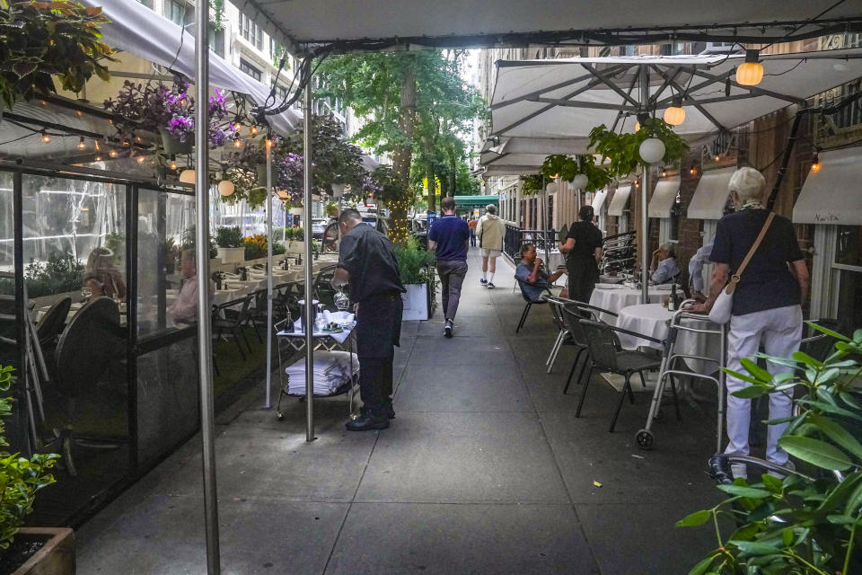 A restaurant's pandemic-era outdoor dining, left, occupy street parking spaces and sidewalk in mid-town Manhattan, Tuesday Aug. 8, 2023, in New York. New York City's roadway dining sheds, a pandemic innovation, are coming under new rules for design and seasonality. (AP Photo/Bebeto Matthews)