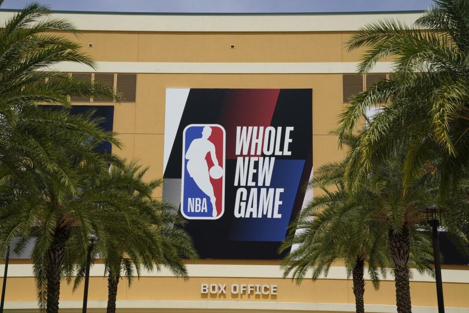 The NBA logo is displayed outside a basketball arena in Lake Buena Vista, Fla.