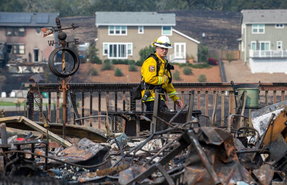 Deputy State Fire Marshal Cliff DuGranrut walks through a pile of debris left from the Glass Fire in Santa Rosa, Calif., on Sept. 29, 2020.