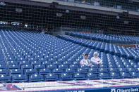 A couple of fans sit in the stands while the start of the game is delayed due to the weather prior to the baseball game between the Cincinnati Reds and the Philadelphia Phillies, Wednesday, April 3, 2024, in Philadelphia. (AP Photo/Chris Szagola)