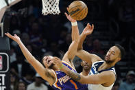 Phoenix Suns guard Devin Booker, left, gets fouled by Minnesota Timberwolves forward Kyle Anderson as they battle for the ball during the second half of an NBA basketball game Wednesday, March 29, 2023, in Phoenix. The Suns won 107-100. (AP Photo/Ross D. Franklin)