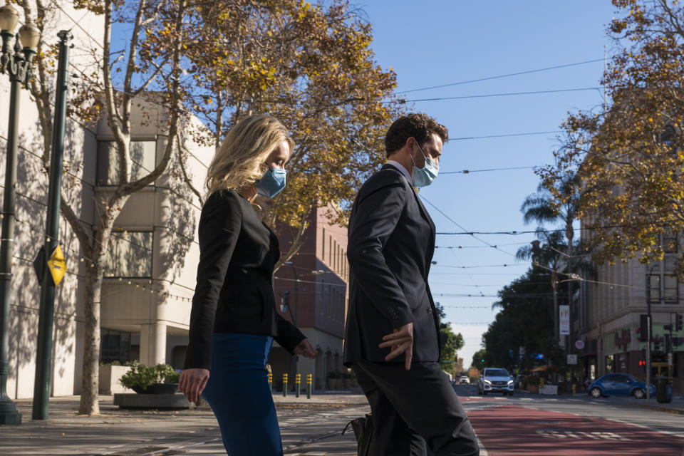 Elizabeth Holmes, center, leaves federal court in San Jose, Calif., Monday, Nov. 22, 2021. Elizabeth Holmes, the one-time medical entrepreneur now charged with building a fraudulent company based on promises of a revolutionary technology, returned to the witness stand Monday. (AP Photo/Nic Coury)