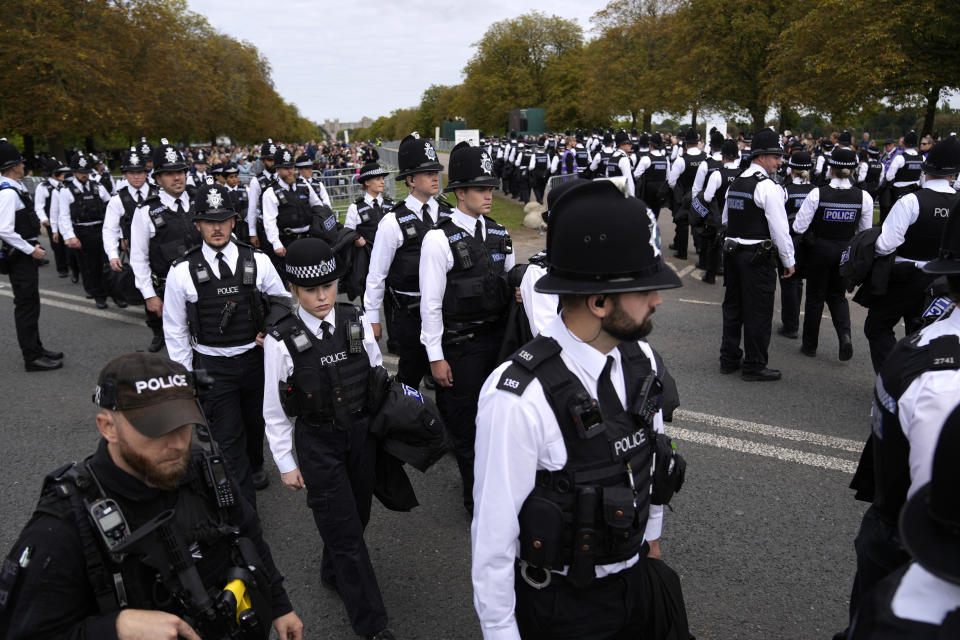 Police gather to take positions as they wait for the arrival of the cortege with the coffin of Queen Elizabeth II outside Windsor Castle in Windsor, England, Monday, Sept. 19, 2022. The Queen, who died aged 96 on Sept. 8, will be buried at Windsor alongside her late husband, Prince Philip, who died last year. (AP Photo/Alastair Grant, Pool)