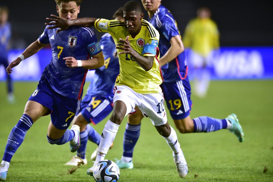 Colombia's Yaser Asprilla, front, controls the ball followed by Japan's Kuryu Matsuki during a FIFA U-20 World Cup Group C soccer match at Diego Maradona stadium in La Plata, Argentina, Wednesday, May 24, 2023. (AP Photo/Gustavo Garello)