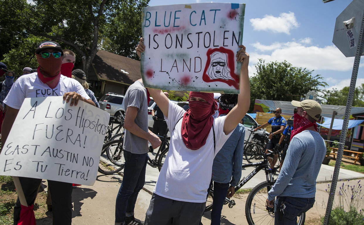 Activists hold signs up signs during protest against Blue Cat Cafe in Austin, Texas, in June 2017. The Jumpolin pinata store previously at the location was torn down. (Photo: Nick Wagner/Austin American-Statesman via AP)