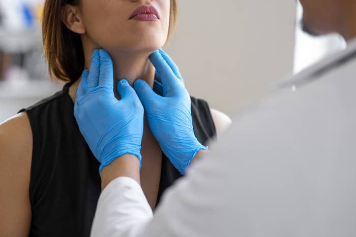 doctor feeling a woman's throat during a check up