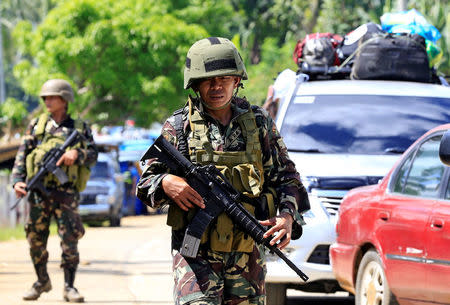 Government troops stand on guard during a checkpoint along a main highway in Pantar town, Lanao del Norte, after residents started to evacuate their hometown of Marawi city, southern Philippines May 24, 2017. REUTERS/Romeo Ranoco