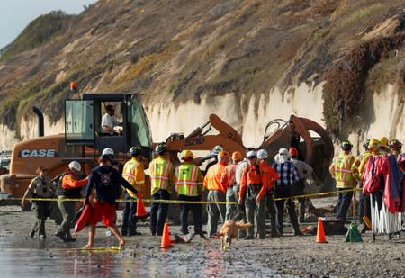 Emergency responders attend to a cliff collapse at a beach in Encinitas, California