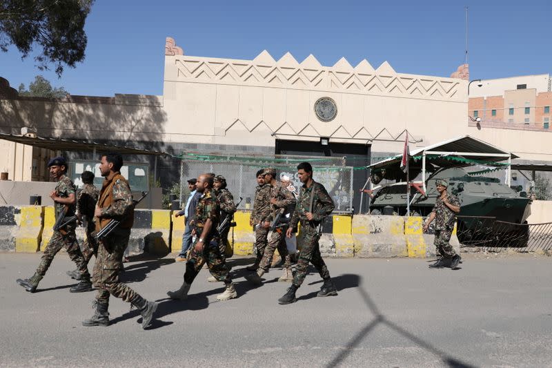 Houthi soldiers walk past the the U.S. embassy's gate following a demonstration against the United States over its decision to designate the Houthis a foreign terrorist organisation, in Sanaa