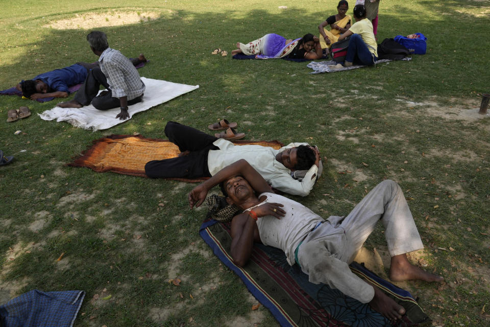 FILE - People rest in the shade of a tree on a hot summer afternoon in Lucknow in the central Indian state of Uttar Pradesh, April 28, 2022. What's considered officially “dangerous heat” in coming decades will likely hit much of the world at least three times more often as climate change worsens, according to a new study. (AP Photo/Rajesh Kumar Singh, File)