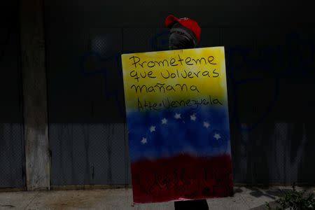 A demonstrator holding a rudimentary shield that reads "Promise me you will come back tomorrow. Venezuela", poses for a picture before a rally against Venezuelan President Nicolas Maduro's government in Caracas, Venezuela, June 17, 2017. He said: "I protest for a better Venezuela, so that we can study, so that our children have a better future and for the freedom of everybody. Because we live in a dictatorship." REUTERS/Carlos Garcia Rawlins SEARCH "RAWLINS PORTRAITS" FOR THIS STORY. SEARCH "WIDER IMAGE" FOR ALL STORIES.