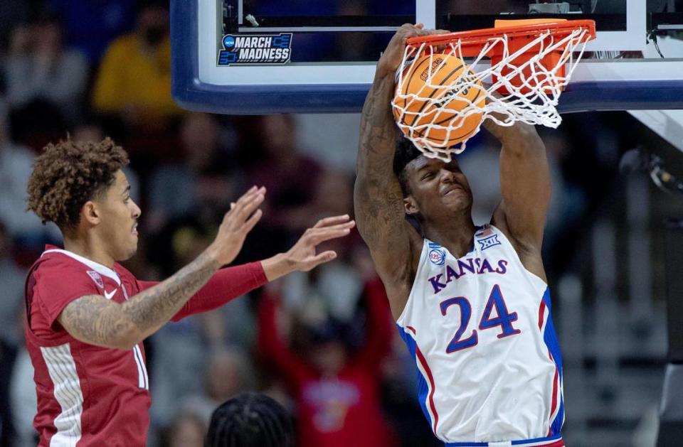 Kansas forward K.J. Adams Jr. (24) dunks the ball as Arkansas forward Jalen Graham (11) defends during a second-round college basketball game in the NCAA Tournament Saturday, March 18, 2023, in Des Moines, Iowa.