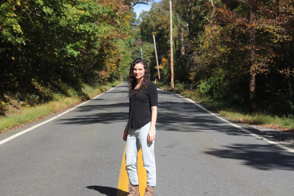 A woman walking in the middle of a road.