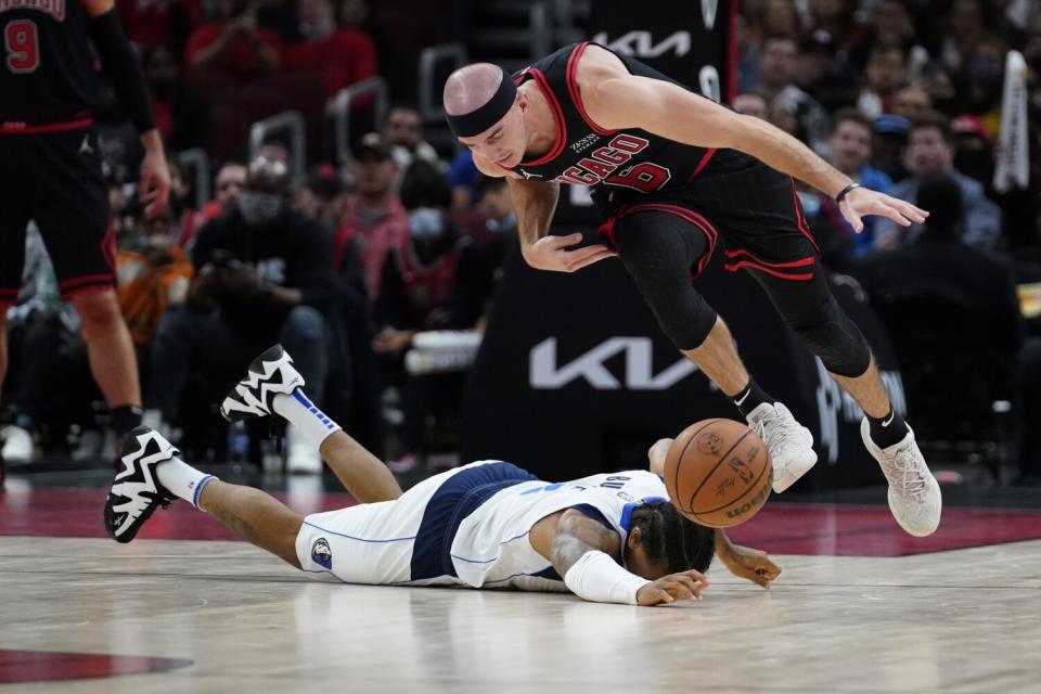 Bulls guard Alex Caruso picks up a loose ball after disrupting the dribble of Mavericks guard Trey Burke.