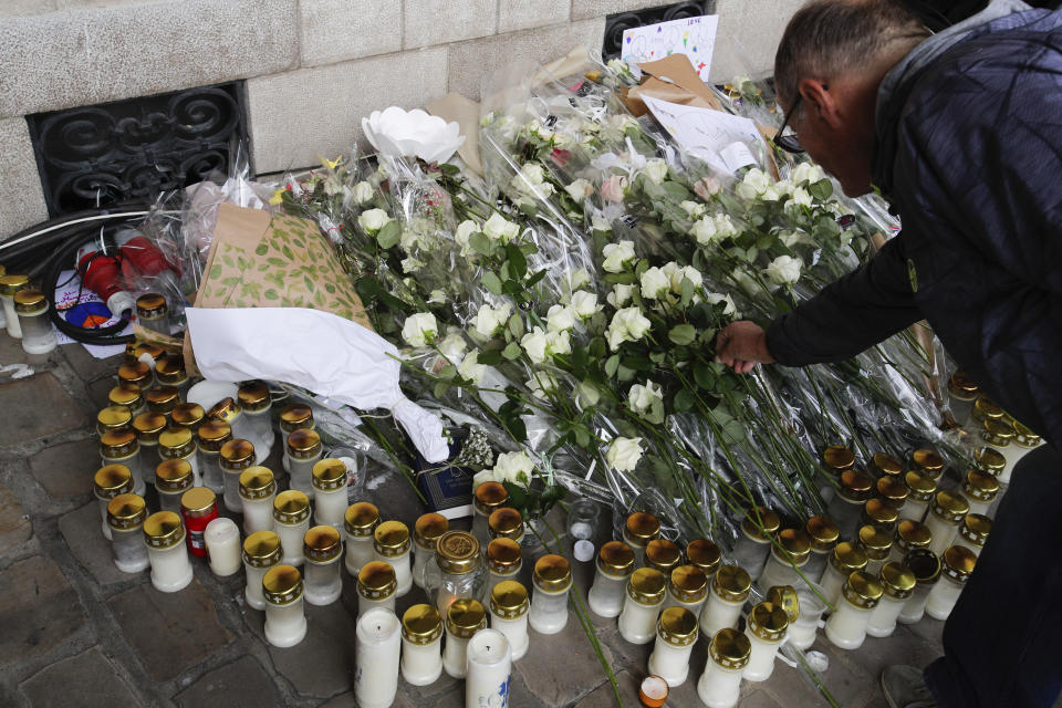 A man places a flower to pay tribute to French teacher Dominique Bernard during his funeral, in Arras, northern France, Thursday, Oct. 19, 2023. Bernard, 57, was stabbed to death at the school by a suspected Islamist extremist. (AP Photo/Michel Spingler)