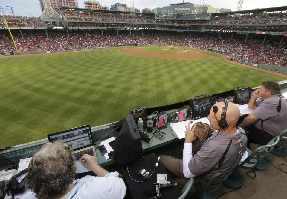 FILE - In this Aug. 3, 2014, file photo, ESPN television broadcasters prepare to cover a baseball game between the New York Yankees and the Boston Red Sox from the top of the Green Monster at Fenway Park, moments before the game, in Boston. ESPN plans to announce it will move up the starting time of the nationally televised game by one hour, with the first pitch planned for shortly after 7 p.m. EDT. The network intends to make the announcement on Monday, Dec. 10, 2018, at the winter meetings, a person familiar with the decision told The Associated Press. The person spoke on condition of anonymity Sunday because the announcement had not yet been made. (AP Photo/Steven Senne, File)