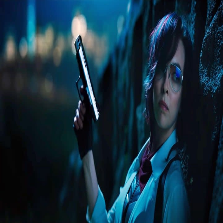 still image from the movie free guy where the character is holding a gun in her hand while looking pensively 