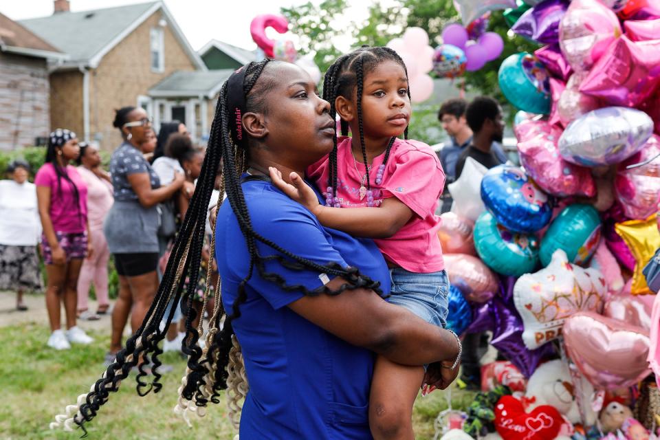 Neighborhood member Keonnia Simmons holds her daughter Lauryn Smith, 6 during a community vigil on Erwin Avenue near Wynter Cole Smith of Lansing, 2, was found in Detroit on Thursday, July 6, 2023.
