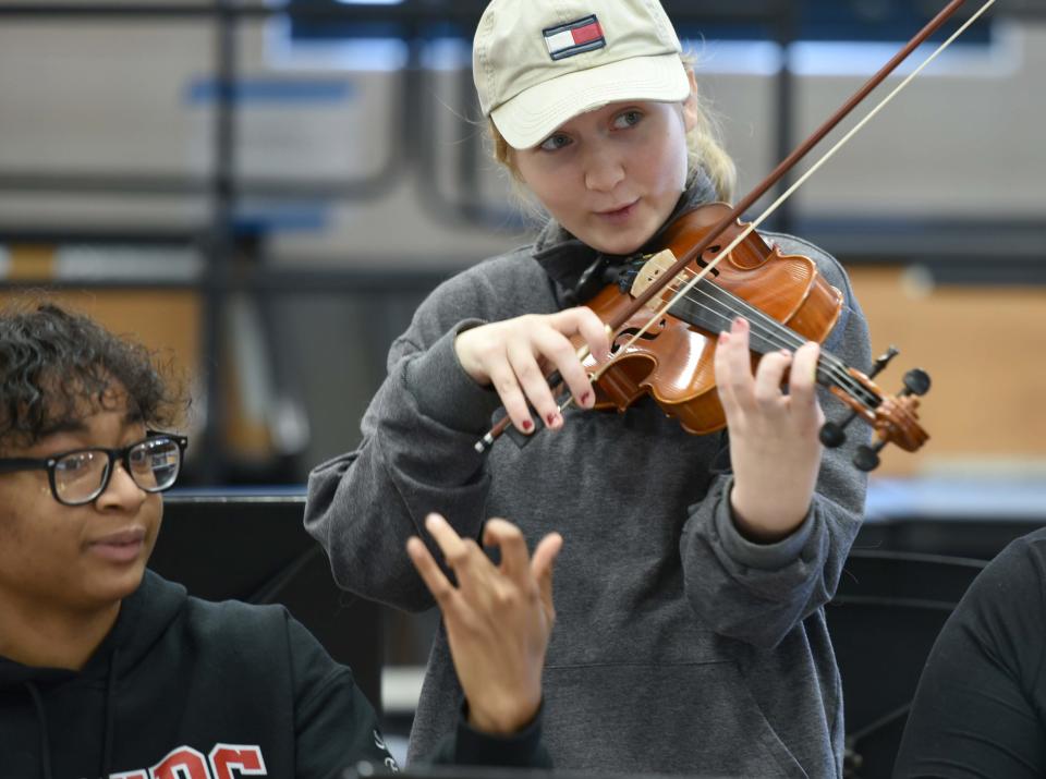 Senior Shantelle Roberts, left, works her way through the notes with one hand as Violet Mae runs through a practice song with her in the Modern Orchestra class at Barnstable High School.
