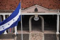 La bandera nacional hondureña ondea frente a la casa presidencial en Tegucigalpa, Honduras.