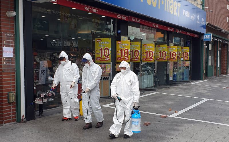 Employees from a disinfection service company sanitize a street in Daejeon