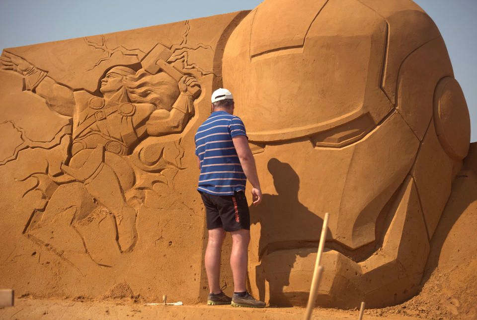 <p>A sand carver works on a sculpture during the Sand Sculpture Festival “Disney Sand Magic” in Ostend, Belgium. (Photo courtesy of Disneyland Paris) </p>