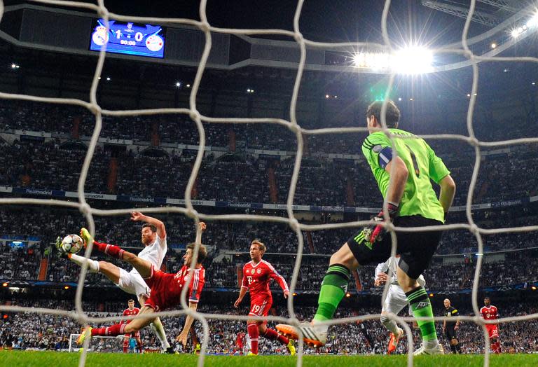 Bayern Munich's midfielder Thomas Mueller (2nd L) vies with Real Madrid's midfielder Xabi Alonso (L) as Real Madrid goalkeeper Iker Casillas looks on during the UEFA Champions League semifinal first leg football match in Madrid on April 23, 2014