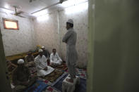 Indian Muslims gather for Eid al-Fitr prayers inside their house in New Delhi, India, Monday, May 25, 2020. The holiday of Eid al-Fitr, the end of the fasting month of Ramadan, a usually joyous three-day celebration has been significantly toned down as coronavirus cases soar. (AP Photo/Manish Swarup)