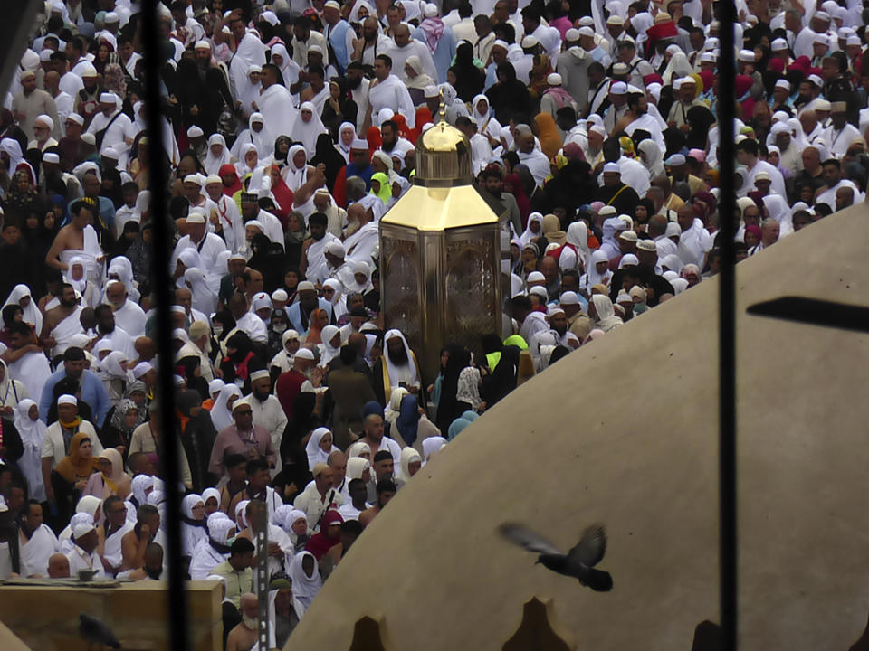 Muslim pilgrims pray surrounding the Maqam Ibrahim, or Station of Abraham, the golden glass structure, center, at the Grand Mosque in the Muslim holy city of Mecca, Saudi Arabia, Monday, Feb. 24, 2020. (AP Photo/Amr Nabil)
