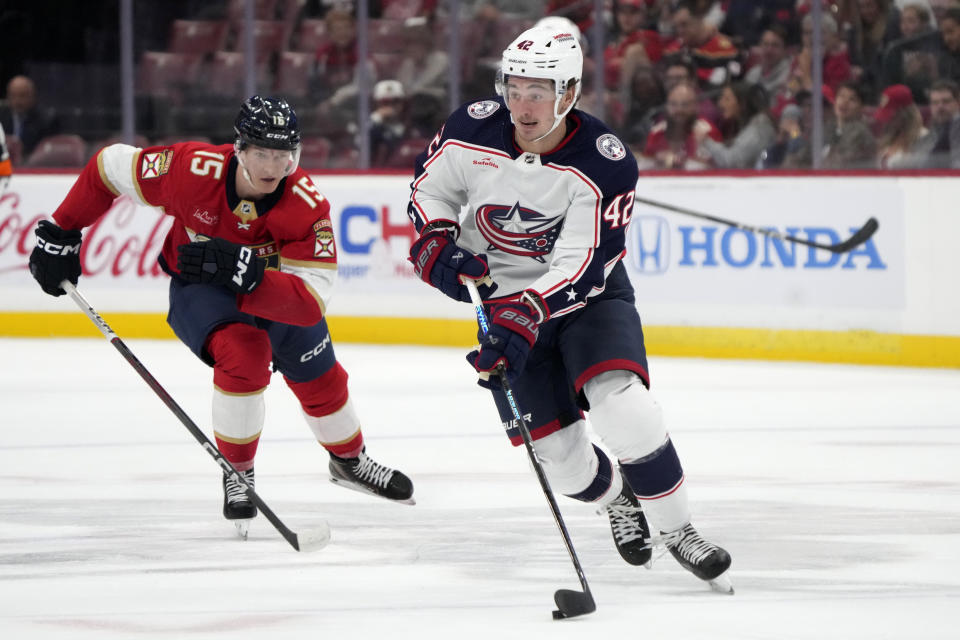 Columbus Blue Jackets center Alexandre Texier (42) takes the puck down the ice against Florida Panthers center Anton Lundell (15) during the first period of an NHL hockey game, Monday, Nov. 6, 2023, in Sunrise, Fla. (AP Photo/Wilfredo Lee)