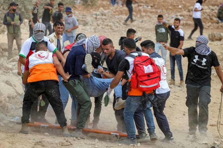 Des manifestants palestiniens et des secouristes évacuent un blessé lors de heurts avec l'armée israélienne à Beita, en Cisjordanie occupée, le 23 juillet 2021 - JAAFAR ASHTIYEH © 2019 AFP