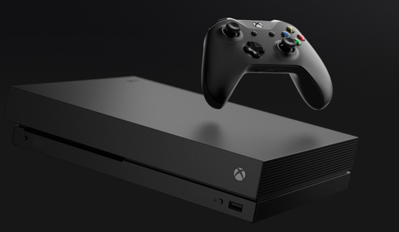 A black Xbox One X is shown floating in the air with a solid black background.