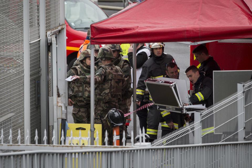 Soldados y rescatistas trabajan en el aeropuerto de Orly, al sur de París, el sábado 18 de marzo de 2017. Un hombre murió baleado en el aeropuerto tras intentar arrebatar su arma a un soldado que protegía el lugar, según la policía, lo que provocó una evacuación parcial de la terminal. (AP Foto/Kamil Zihnioglu)