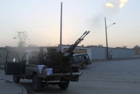 Rebel fighters fire an anti-aircraft weapon towards what activists said was a helicopter belonging to forces loyal to Syria's President Bashar al-Assad and dropping a barrel bomb in the old city of Aleppo November 12, 2014. REUTERS/Abdalrhman Ismail