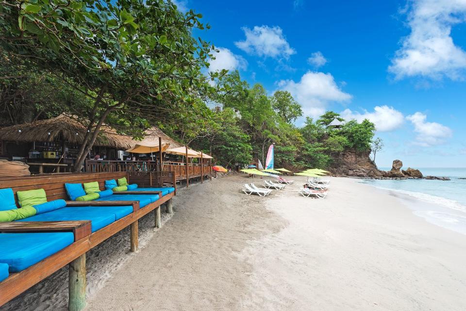 a beach with lounge chairs and umbrellas