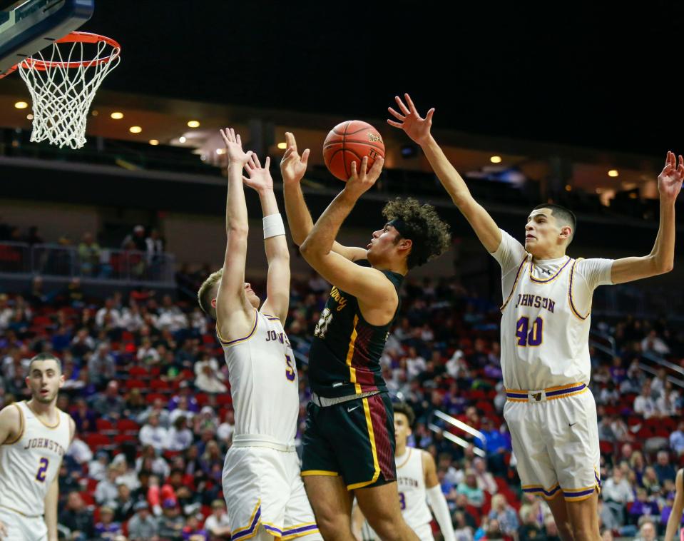 Ankeny's Lio Aguirre shoots the ball in traffic against Johnston during the Iowa high school boys basketball tournament at Wells Fargo Arena in Des Moines on Wednesday, March 9, 2022.